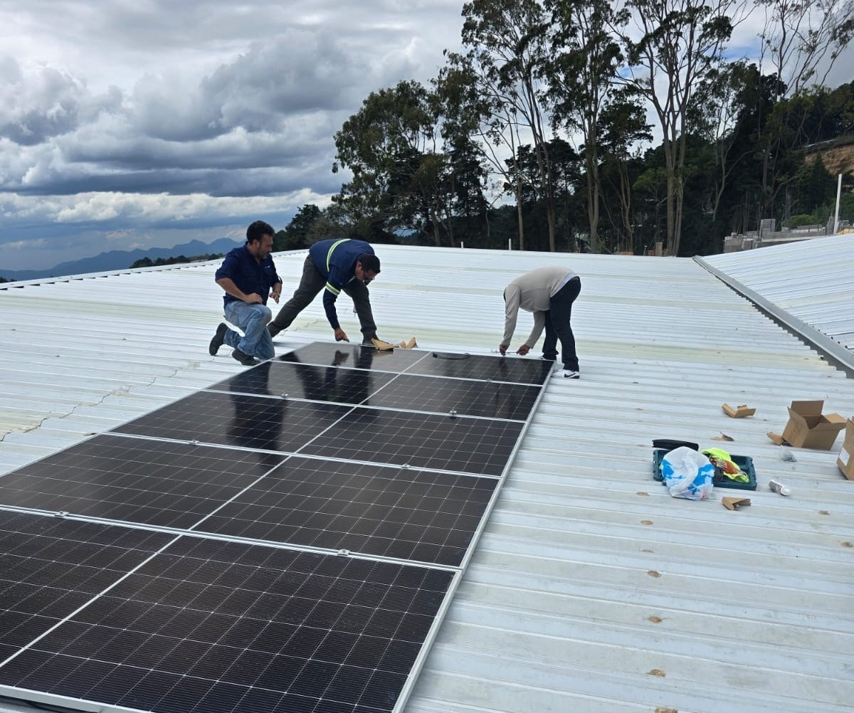 Cuadrilla de Comcast Group instalando un arreglo de paneles solares en techo industrial